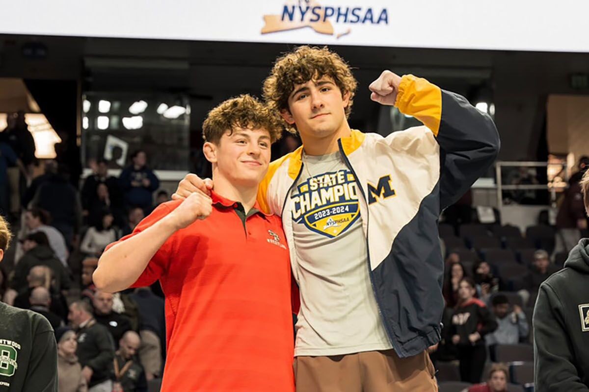first and second place champions from kd6 wrestling stand at the podium at a nysphsaa event 